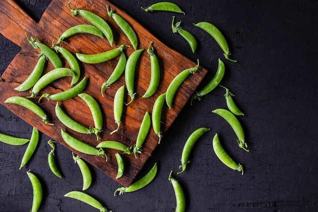 Guisantes verdes frescos en el fondo de madera