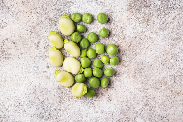 Guisantes verdes frescos y frijoles sobre fondo claro