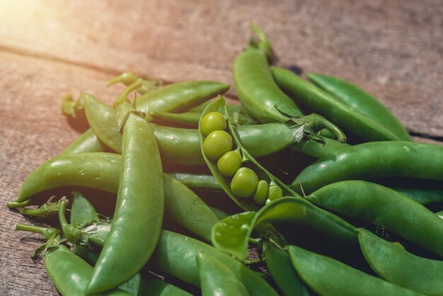 Guisantes verdes o frijoles en la mesa de madera