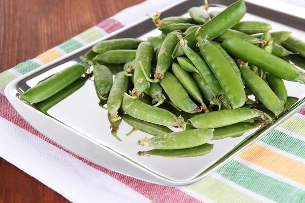 Guisantes verdes en servilleta en primer plano de la mesa