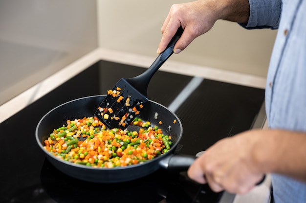 Guisar verduras de colores en una sartén