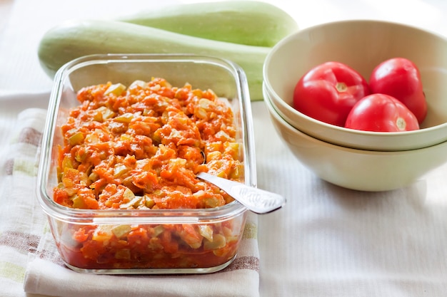 Guiso de calabaza con zanahoria y tomate en un plato cuadrado de vidrio