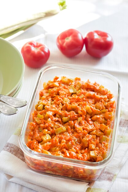 Guiso de calabaza con zanahoria y tomates en un plato cuadrado de vidrio