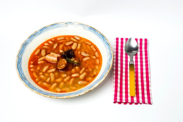 Guiso de frijoles con chorizo ​​y cerdo. Aislado.