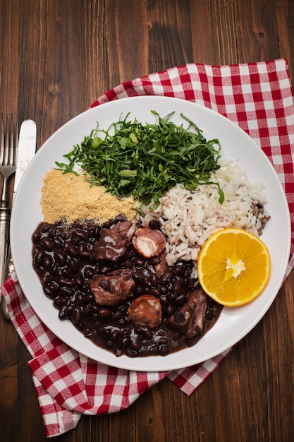 Guiso de frijoles negros con salchichas en un plato blanco