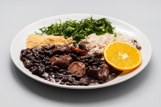 Guiso de frijoles negros con salchichas en un plato blanco