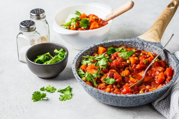 Guiso de frijoles veganos con tomate y arroz en una sartén