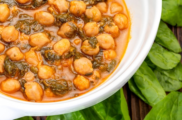 Guiso de garbanzos con espinacas (potaje). Delicioso plato de cuchara para otoño e invierno. Comida tradicional. Primer plano.