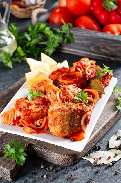 Guiso de pescado con tomate en un plato blanco