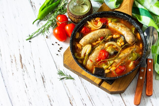 Guiso de verduras frijoles y salchichas ahumadas con salsa de tomate Espacio de copia