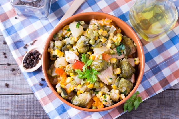 Guiso de verduras Verduras guisadas en un plato sobre una mesa de madera antigua