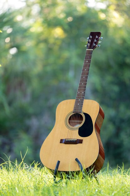 Guitarra acústica al aire libre sobre fondo verde Concepto de música tranquila