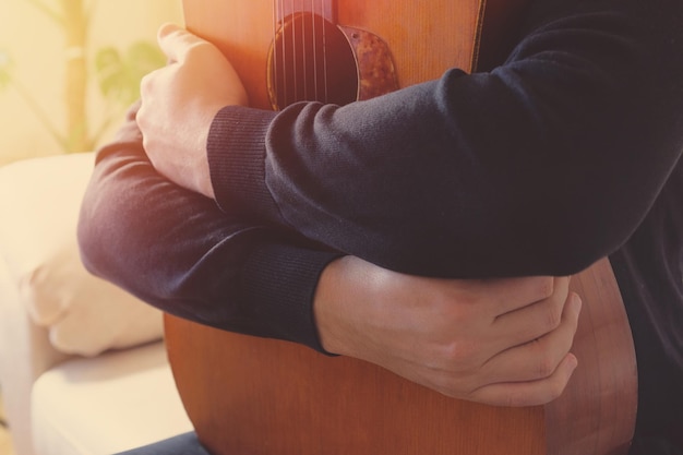 Guitarra acústica clásica y manos de un músico concepto musical de primer plano