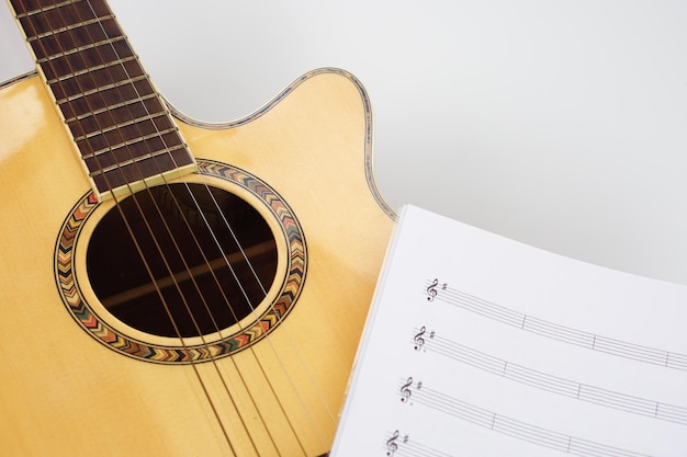 Guitarra acústica com notas musicais em fundo branco Amo música e conceito de aprendizagem