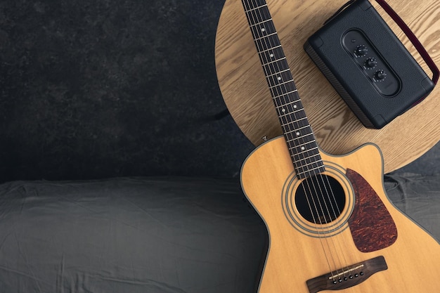 Guitarra acústica e alto-falante na mesa em cima do espaço de cópia