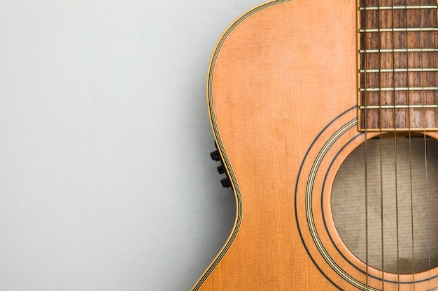 Guitarra acústica de madera sobre un fondo liso