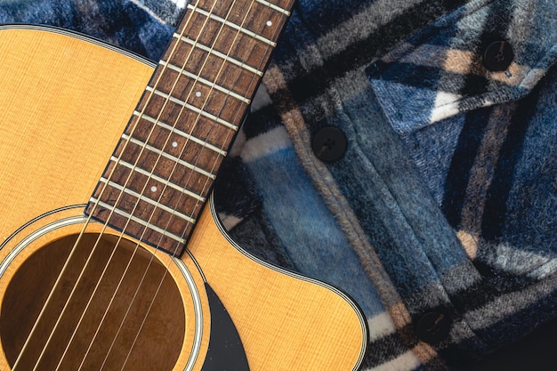 Guitarra acústica de primer plano en el fondo de la camisa