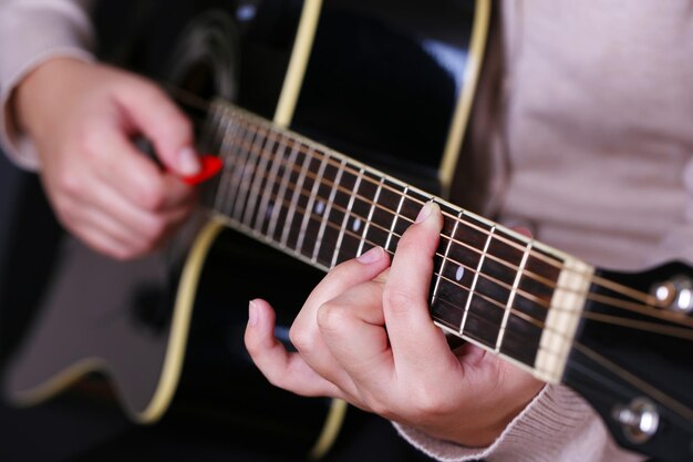 Guitarra acústica en primer plano de manos femeninas