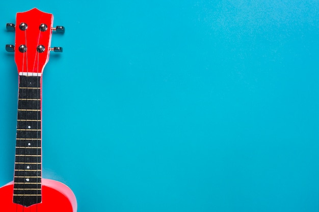 Foto guitarra acústica roja sobre fondo azul