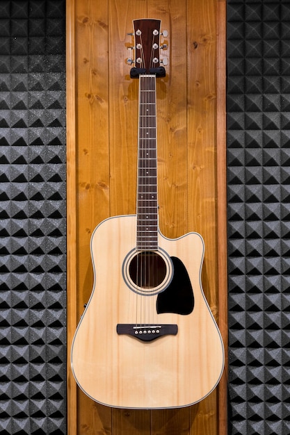 Guitarra clásica colgada en la pared en el estudio de grabación