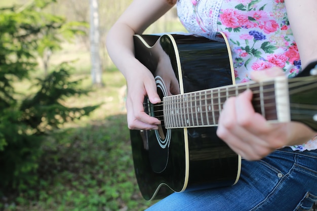 Guitarra cuerda mujer mano al aire libre