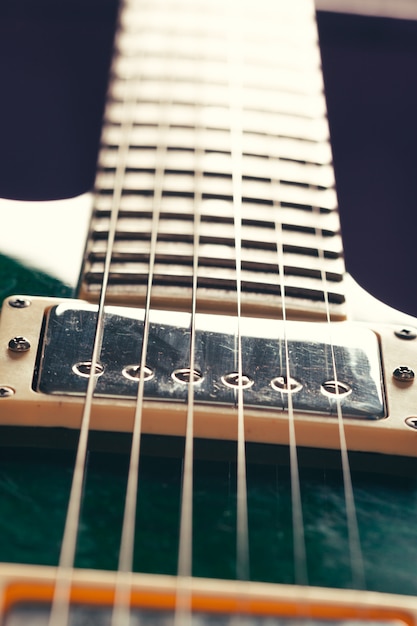 Guitarra electrica con cuerpo y detalle de mástil en madera.