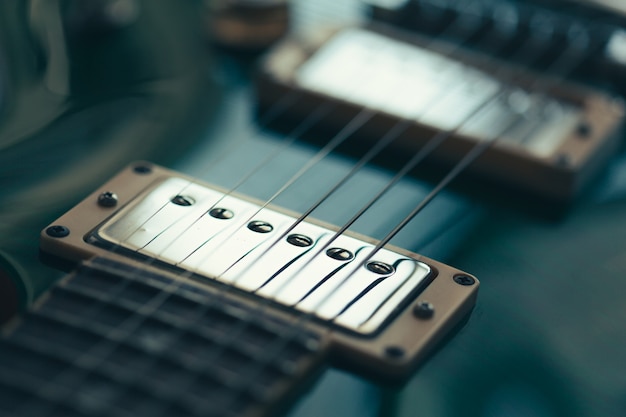 Foto guitarra electrica con cuerpo y detalle de mástil en madera.