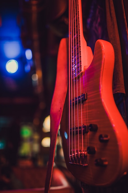 Guitarra eléctrica roja y amplificador clásico sobre un fondo oscuro.