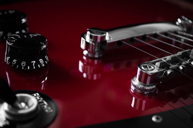 Guitarra eléctrica roja con cuerdas en el cuello diapasones closeup aislado sobre fondo negro