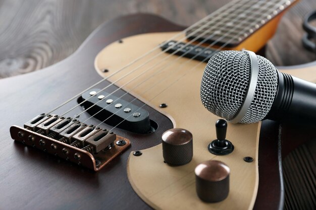 Guitarra elétrica com microfone na mesa de madeira close-up