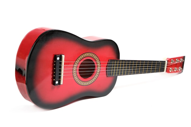 Guitarra infantil de seis cuerdas en rojo sobre fondo blanco.