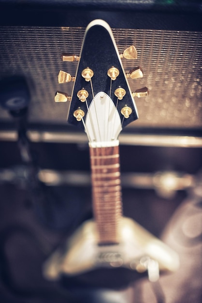 La guitarra con más sonido Vista de ángulo alto de una guitarra apoyada en un amplificador