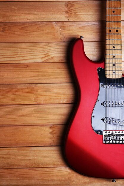 Guitarra roja sobre fondo de madera