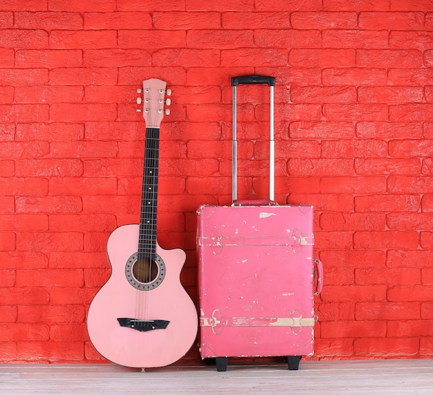 guitarra rosa y maleta de viaje rosa vintage