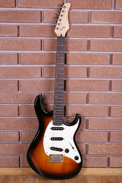 Foto guitarra sobre fondo de pared de ladrillo