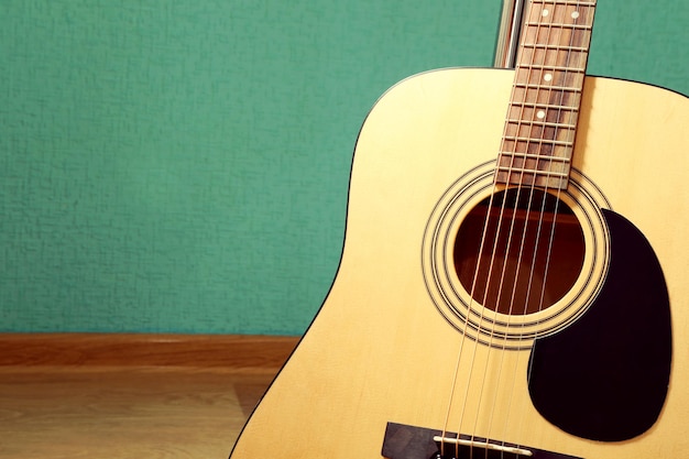 Guitarra en el suelo contra el fondo azul en el estudio de cerca