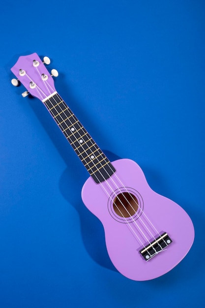 Guitarra ukulele de quatro cordas no fundo azul