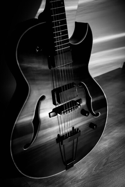 Foto guitarras de jazz archtop negras con agujeros de acero hueco con cuerdas acústicas o semiacuticas