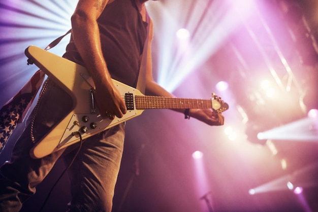 Guitarrista y actuación para concierto de rock o canto en fiesta o celebración en la noche Músico masculino o estrella de rock con instrumento en festival de música para sonido artístico o talento en el escenario