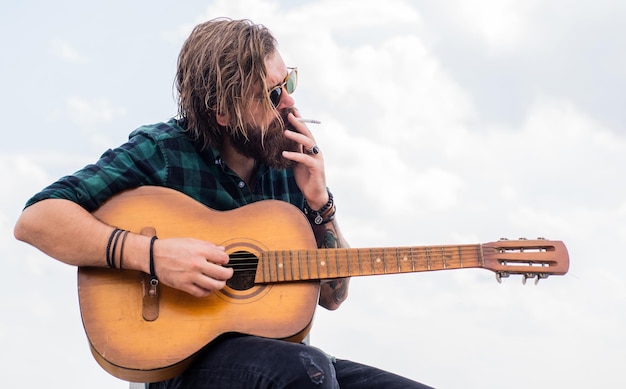 Guitarrista acústico músico hipster maduro com barba cara caucasiano brutal tocando guitarra música country homem barbudo cantando música homem bonito cantor e guitarrista