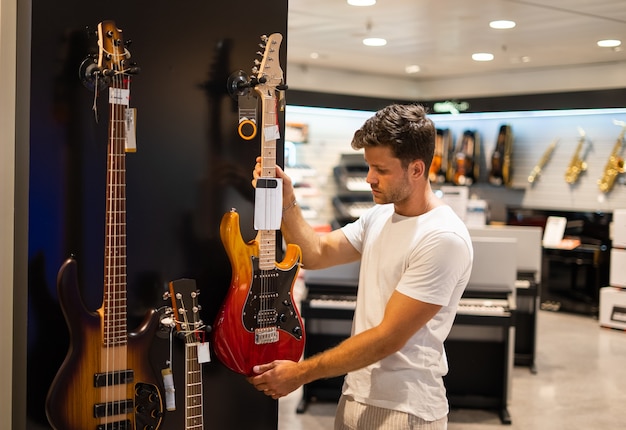 Guitarrista comprando instrumentos musicales en la tienda