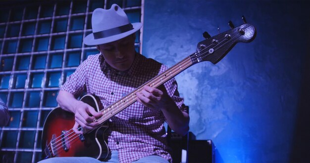 Guitarrista em cena em bar músico de chapéu toca guitarra