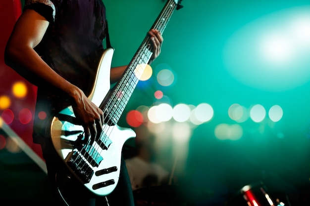 Guitarrista bajo en el escenario para el fondo