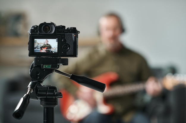 Guitarrista grabando su actuación en cámara.