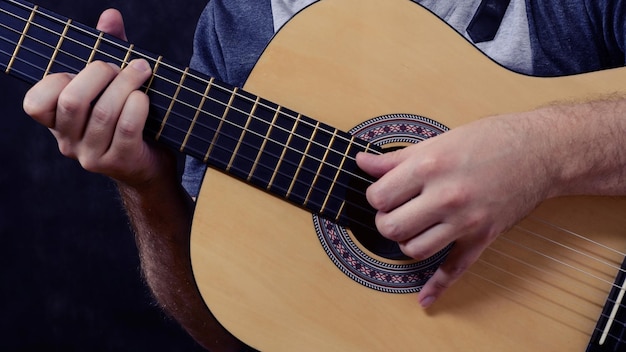 Guitarrista de guitarra acústica tocando detalles Instrumento musical con manos de ejecutante