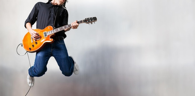 Guitarrista masculino tocando música e pulando