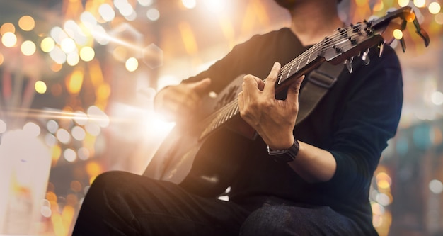 Foto guitarrista no palco e canta em um concerto