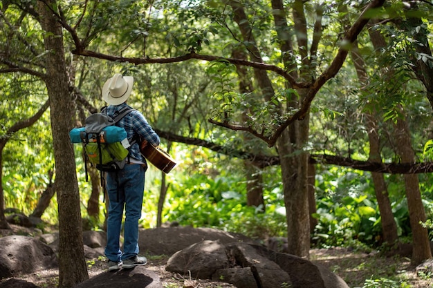 Guitarrista con sombrero de vaquero en la naturaleza