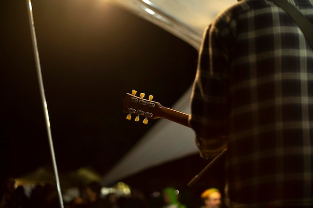 Foto guitarrista sostiene la actuación de guitarra del músico en el festival de música reggae fuera de la persona