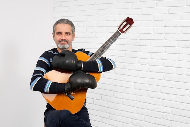 Guitarrista usando luvas de boxe posando.